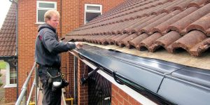Roofer installing guttering replacement